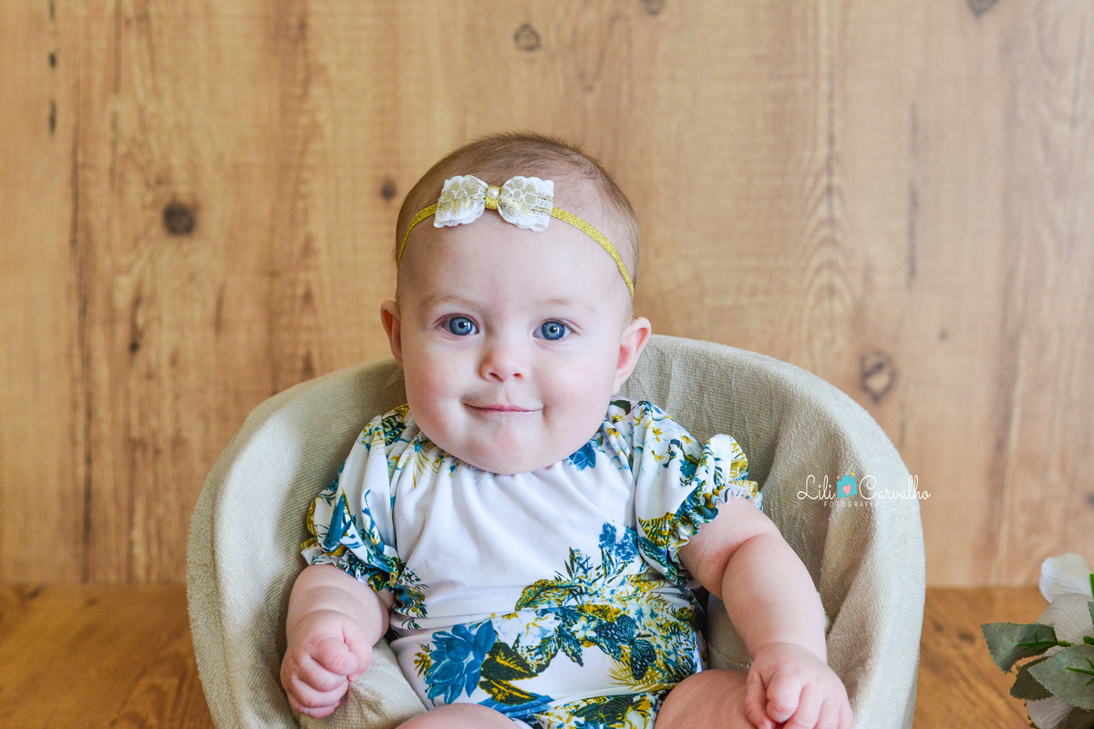 ensaio fotografico em estudio em Maringá, ensaio com bebê menina sentada fazendo caretinha
