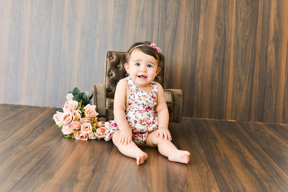 fotografia mensal de  menina em Maringá, menina sentada em sofa, olhando para frente
