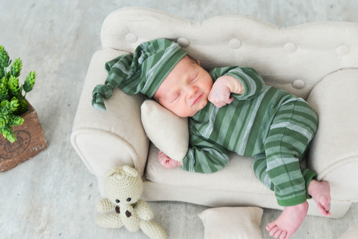 bebê com a mão no rosto, dormindo 