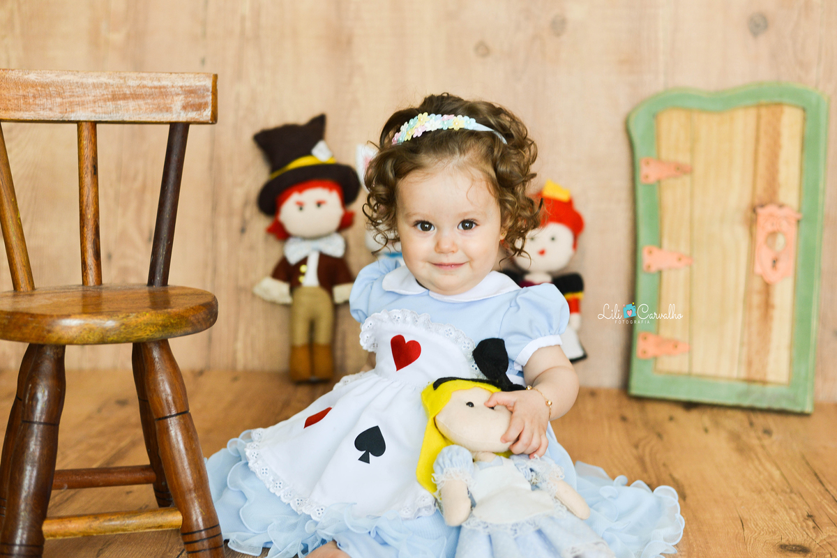 criança sorrindo, vestida de Alice no país das maravilhas