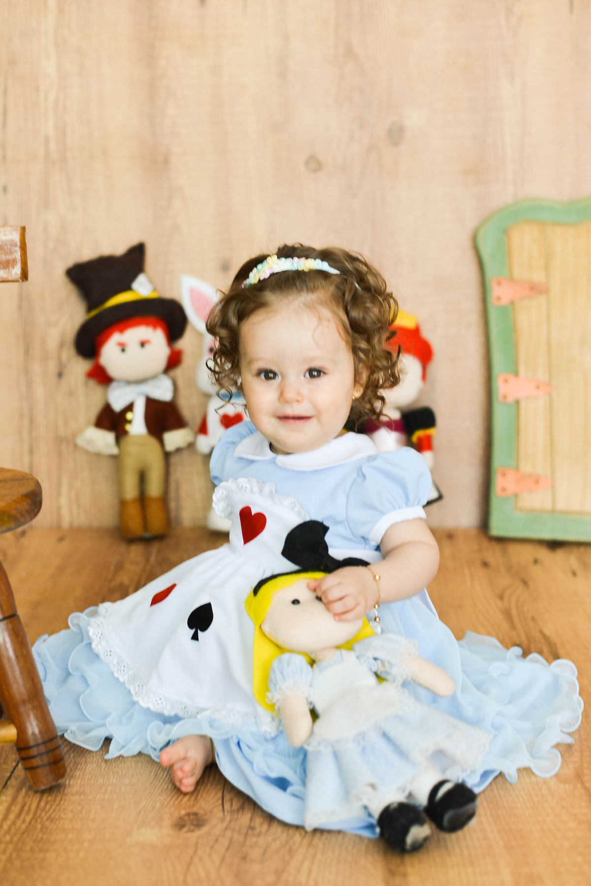 criança sentada, vestida de Alice no país das maravilhas em Maringa 