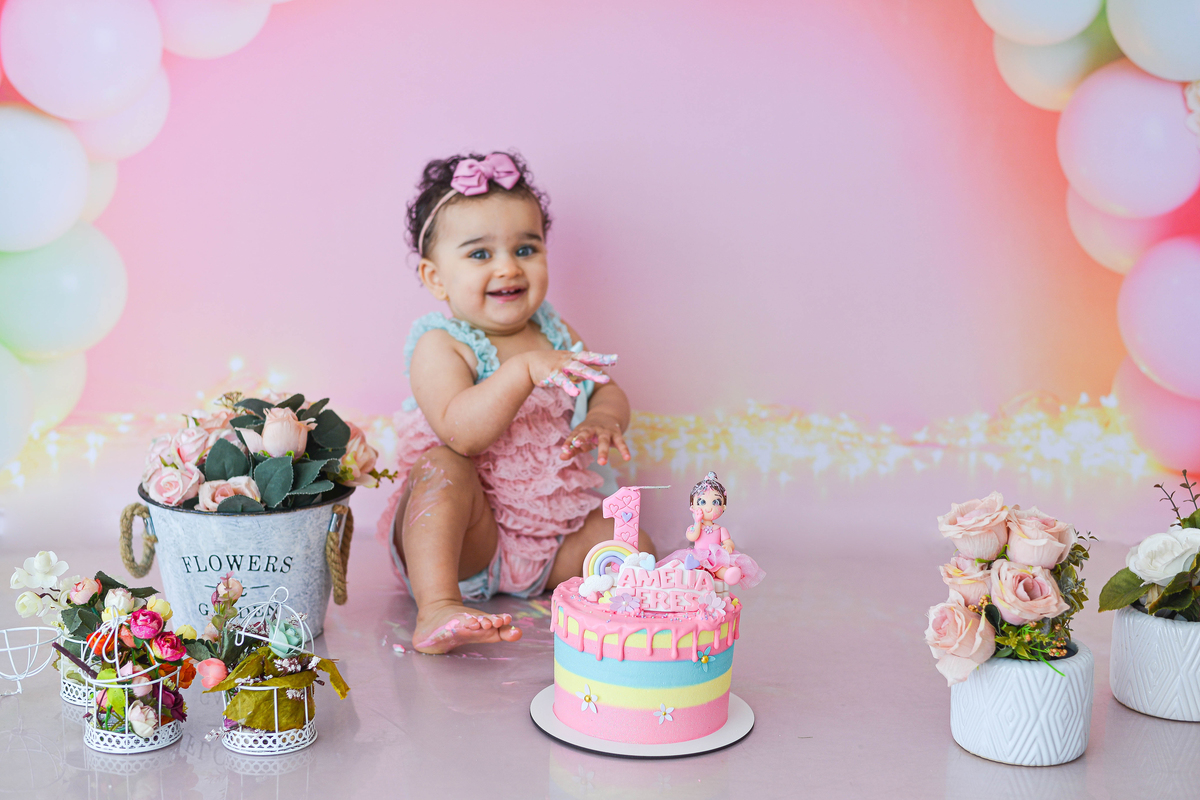 fotografia de criança de smash the cake no estudio em maringá  sorrindo 