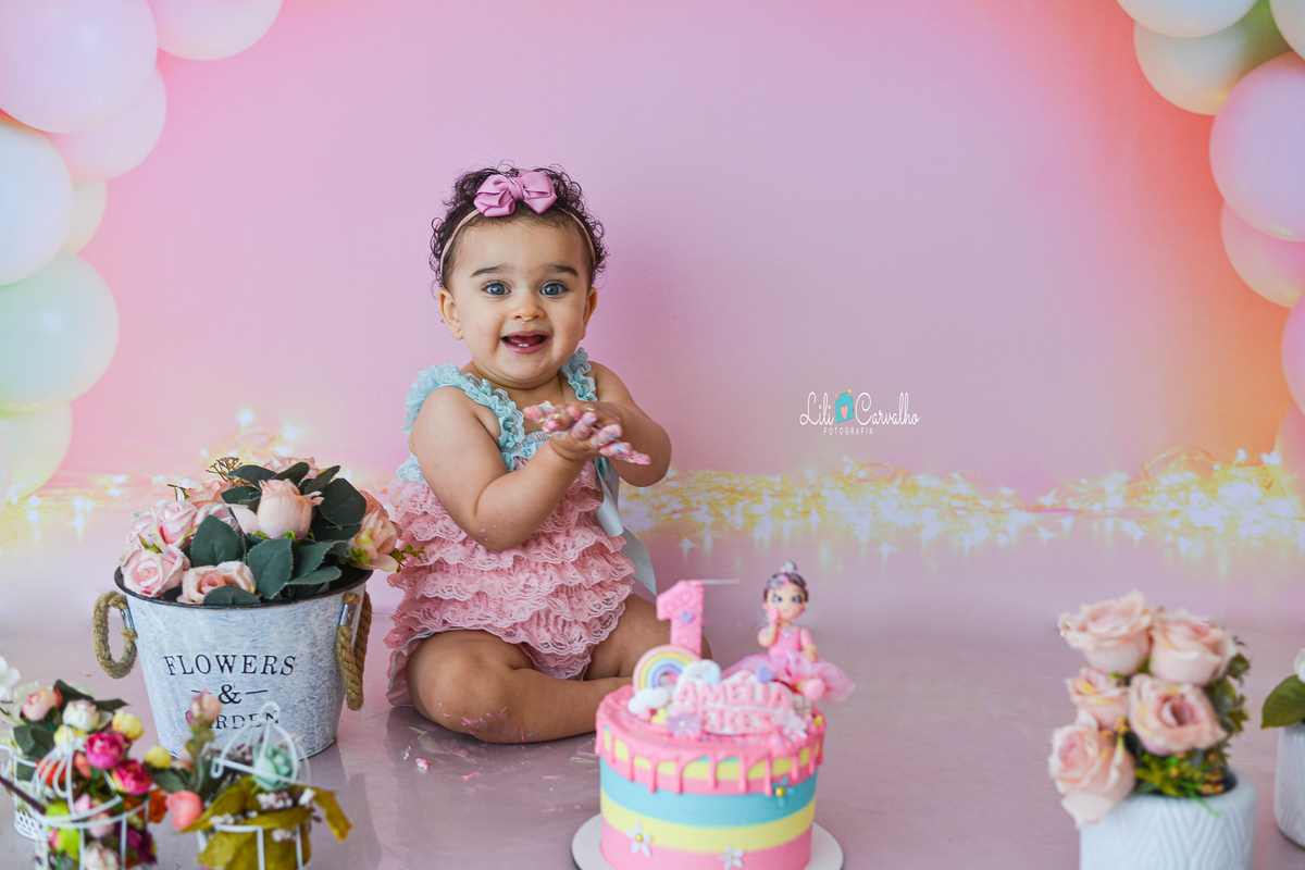 fotografia de criança de smash the cake no estudio em maringá  menina batendo palmas 