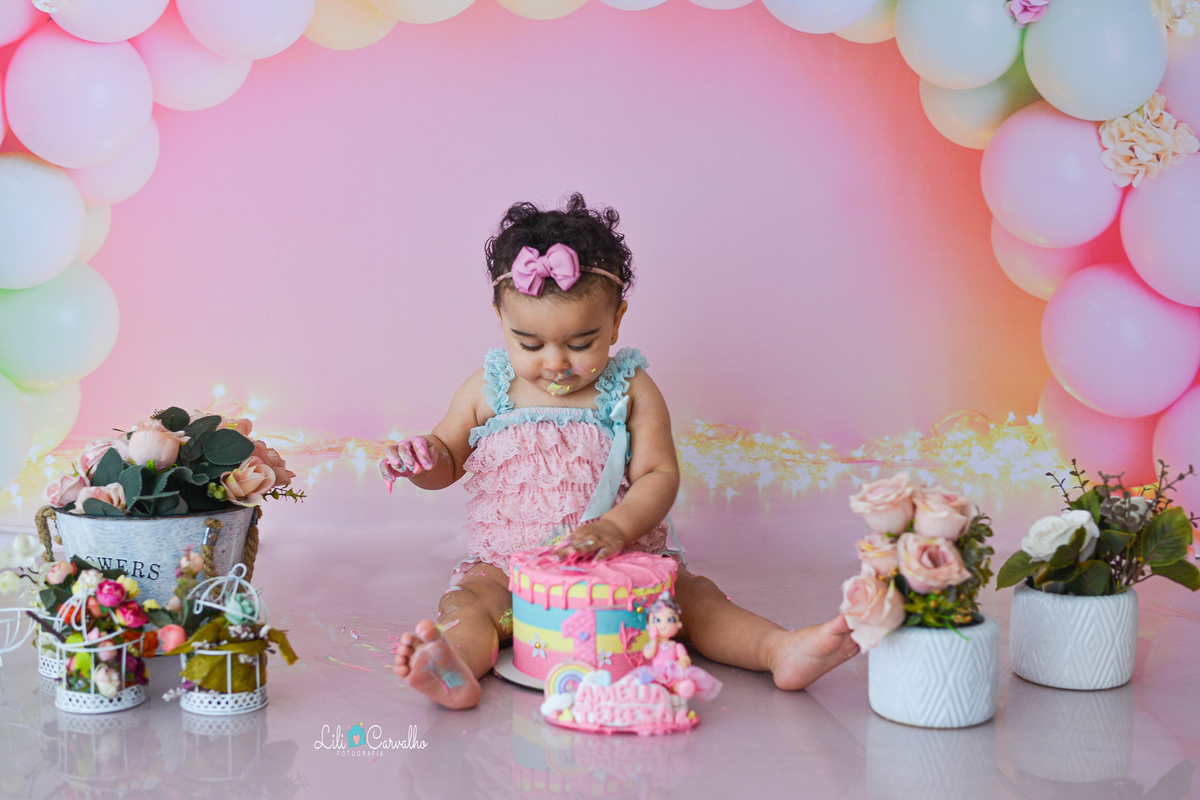fotografia de criança de smash the cake no estudio em maringá  pegando no bolo 
