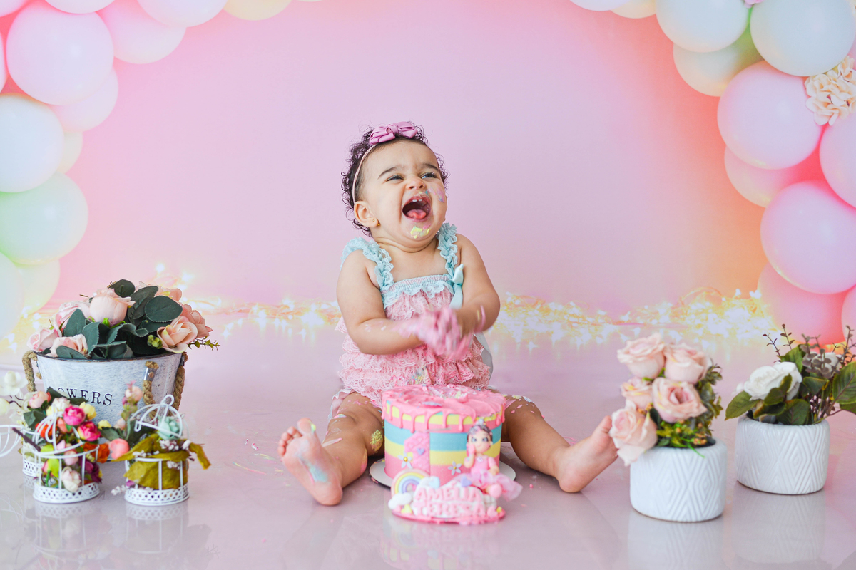 fotografia de criança de smash the cake no estudio em maringá  muito sorridente 