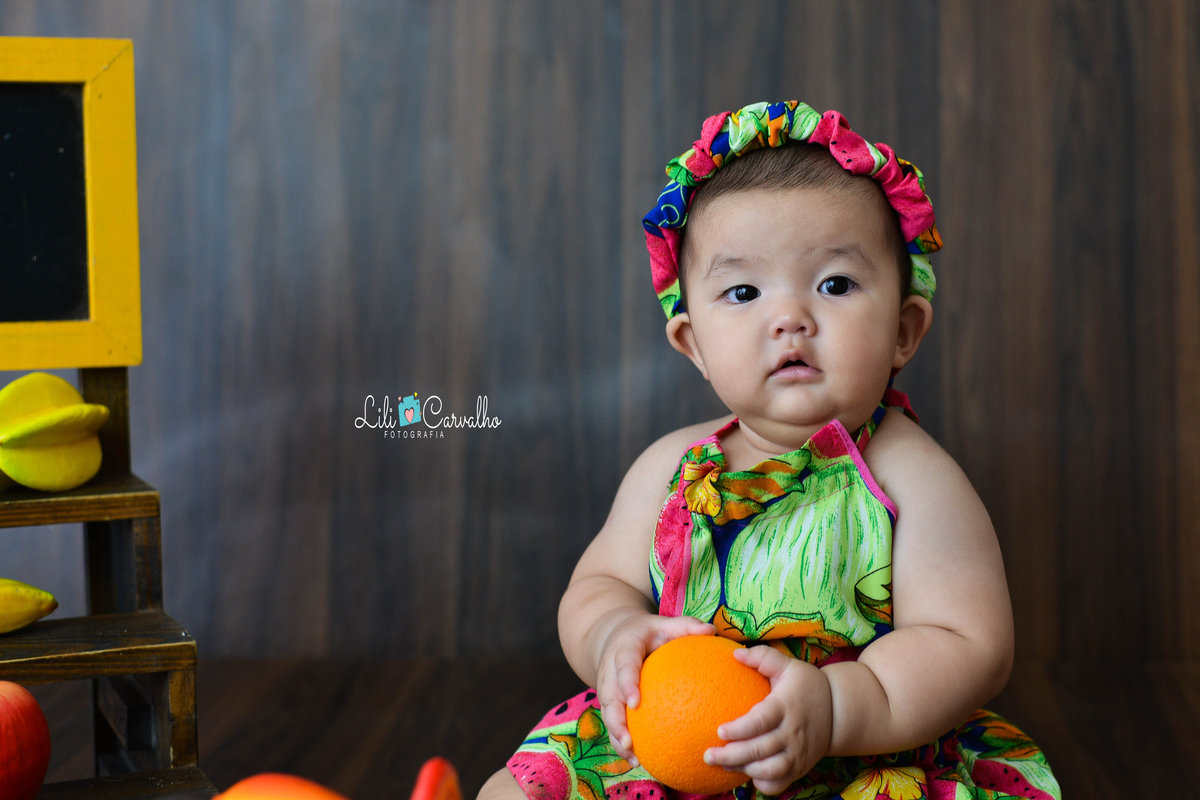 fotografia de bebe no estudio em Maringá segurando fruta