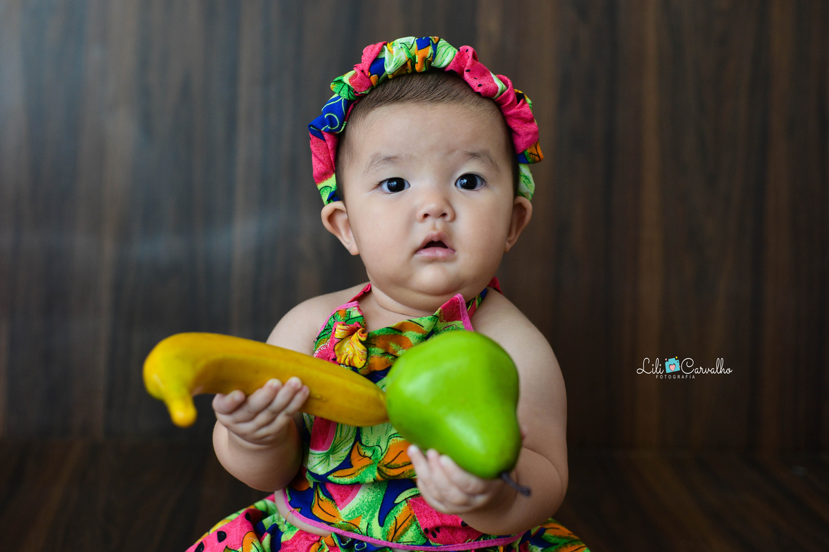 fotografia de bebe no estudio em Maringá com pera na mão 
