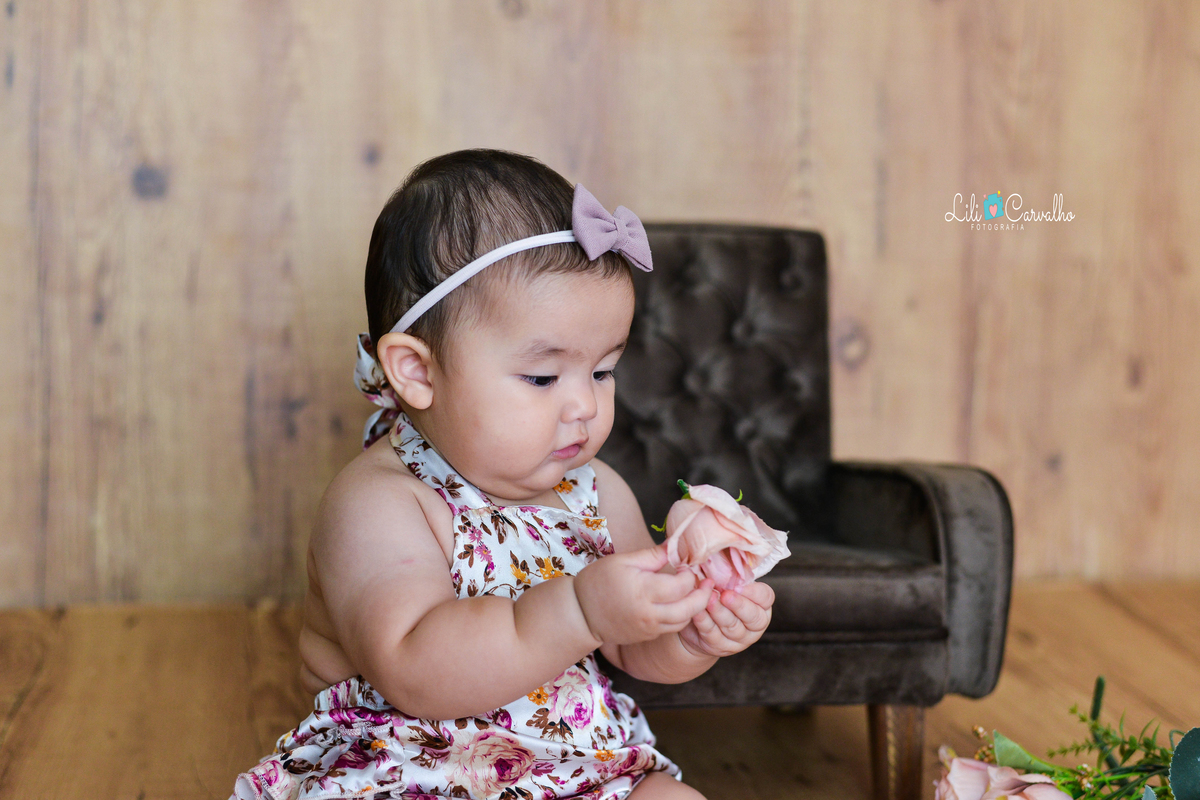 fotografia de bebe no estudio em Maringá pegando a rosa 