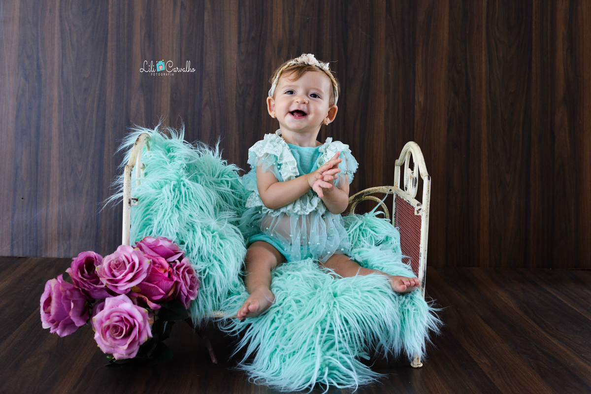 Fotografia de acompanhamento infantil realizada no estudio em Maringá batendo palmas no berco 