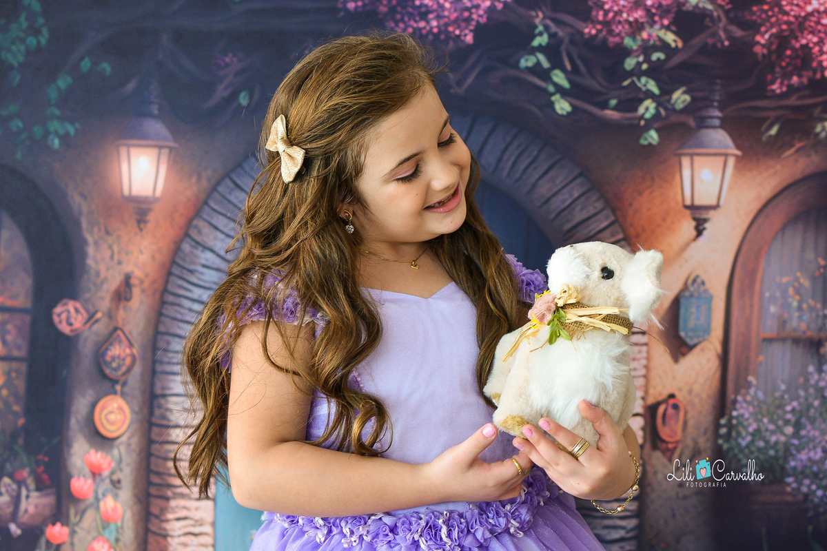 Foto de menina no estudio em Maringá,. vestido lilas olhando coelhinho, tema páscoa, 