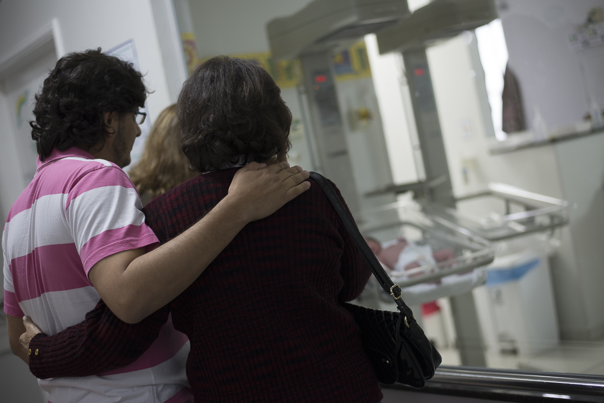 papai e vovos olhando a princesinha no bercario