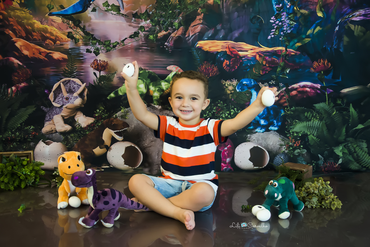 fotografia de menino no tema dinossauro no estudio em Maringá  erguendo as mãos  