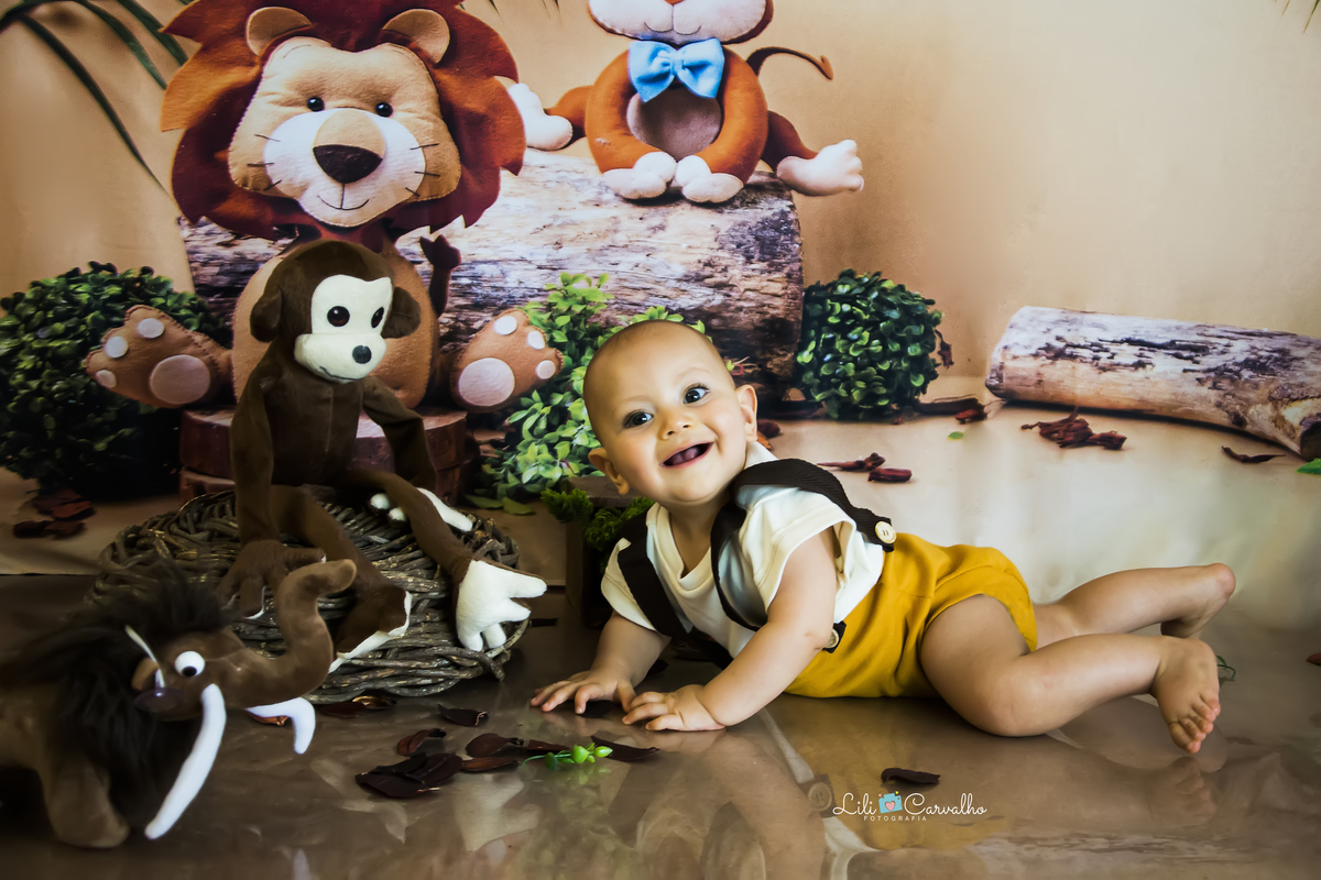 Ensaio fotográfico de bebê em maringá no tema safari deitado com roupa mostarda 