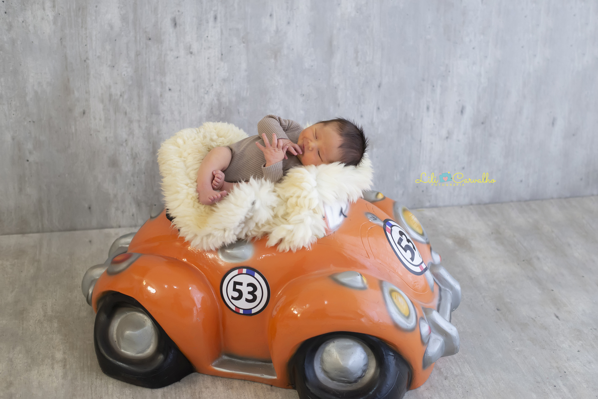 fotografia de bebe recem nascido em Maringá  carrinho laranja 