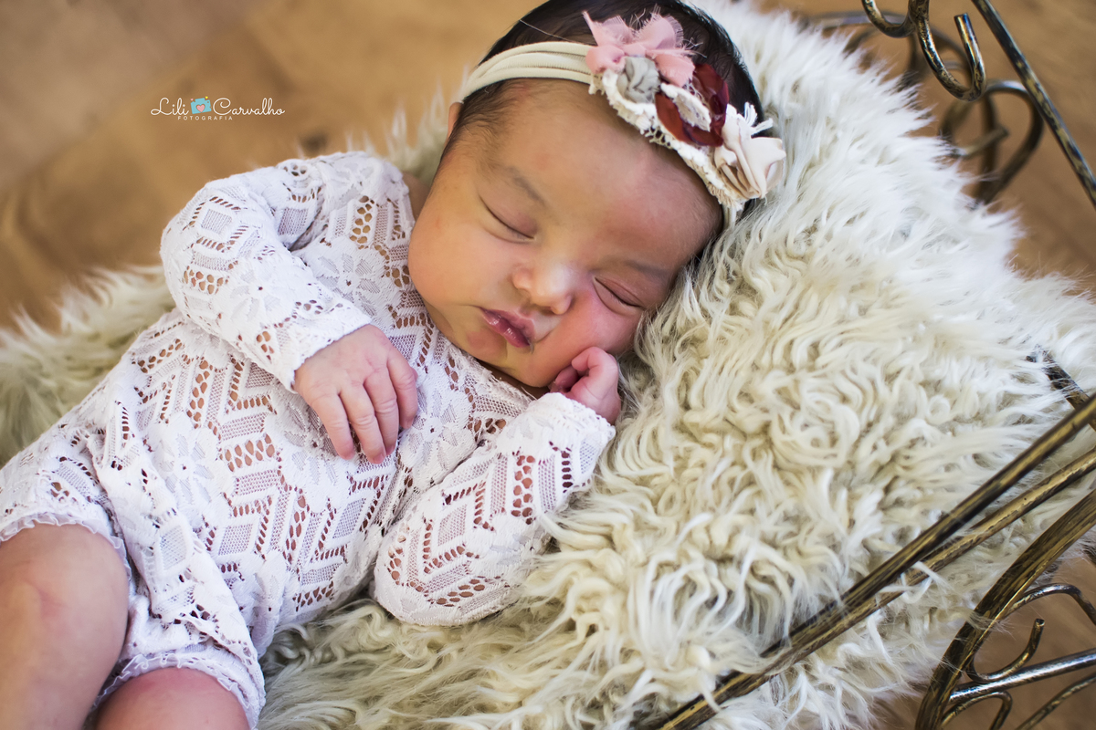 fotografia de newborn realizado em estúdio em Maringá  carruagem e mao no rosto 