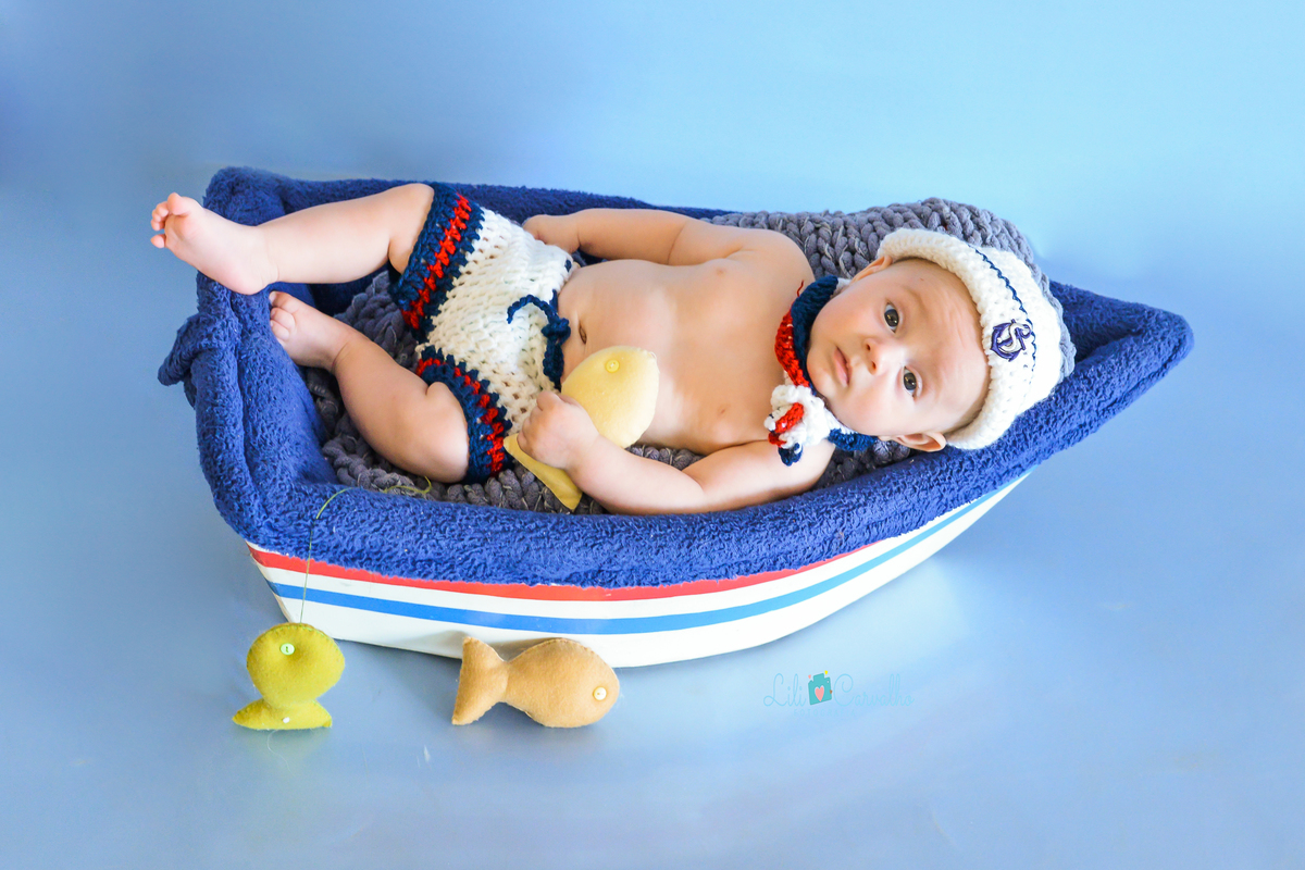 ensaio fotografico de menino realizado em estúdio em Maringá barquinho 