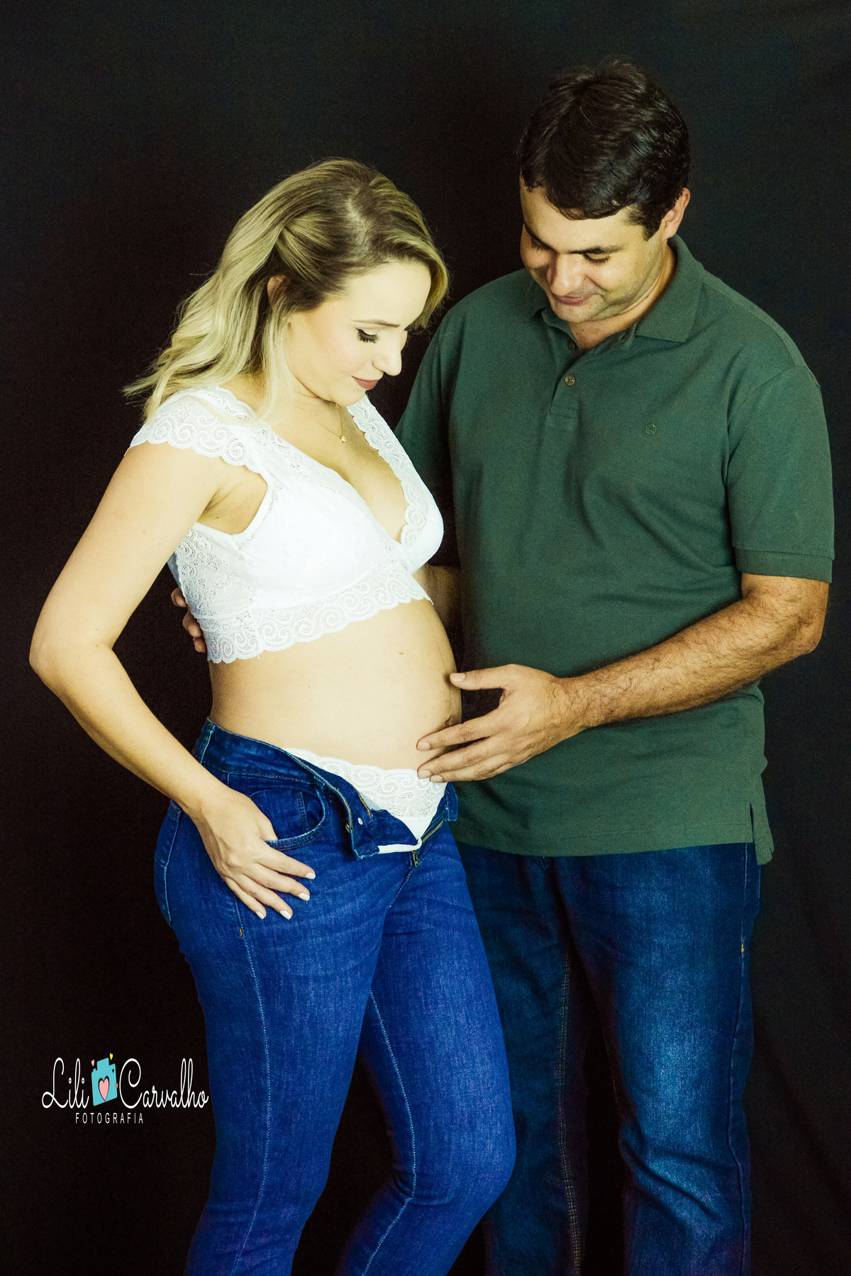 ensaio gestante no estúdio em Maringá olhando para barriga