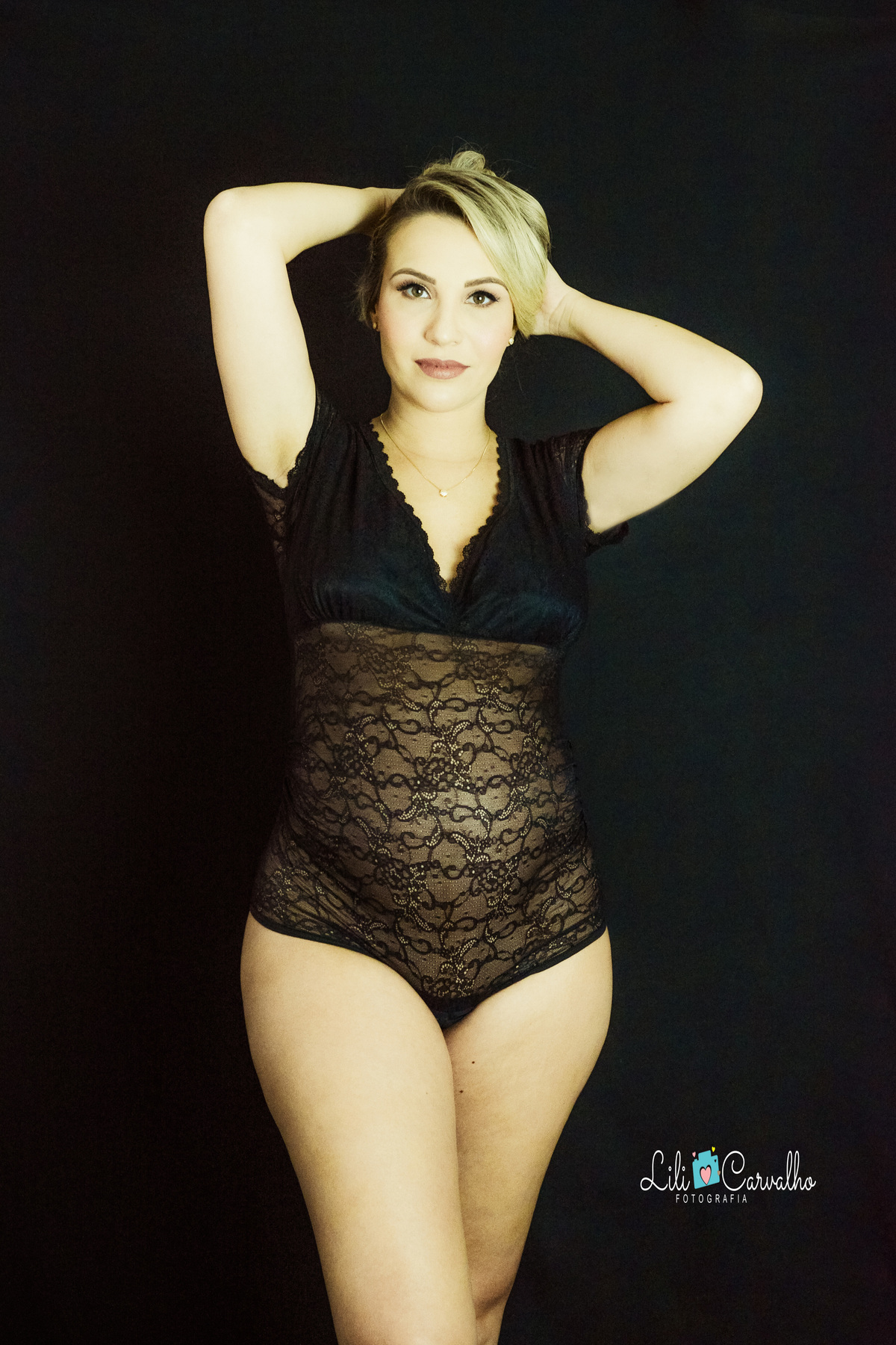 ensaio gestante no estúdio em Maringá, fundo preto, mão na cabeça