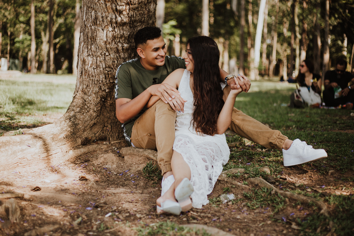casal sentados no parque sorrindo
