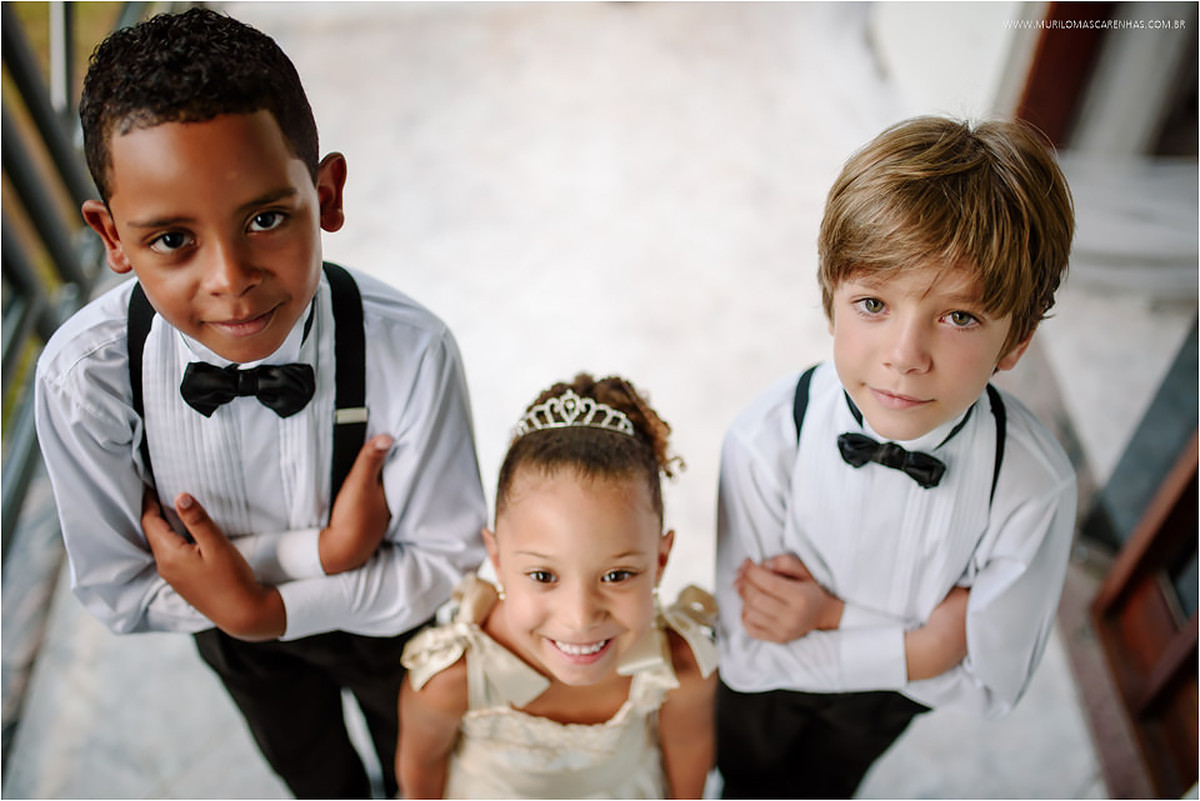 Daminha e pajens com braços cruzados sorrindo
