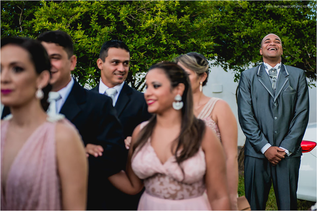 Noivo sorri ansioso no final da fila de entrada da cerimônia