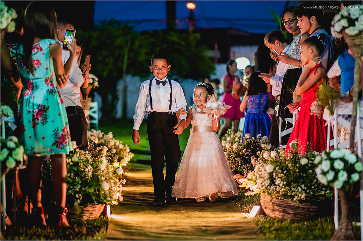 Daminha de vestido e pajem com suspensórios e gravata borboleta entram na cerimônia antes da noiva