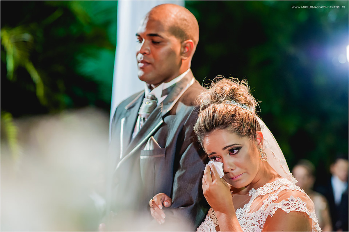 Noiva enxuga suas lágrimas emocionada, com noivo ao lado