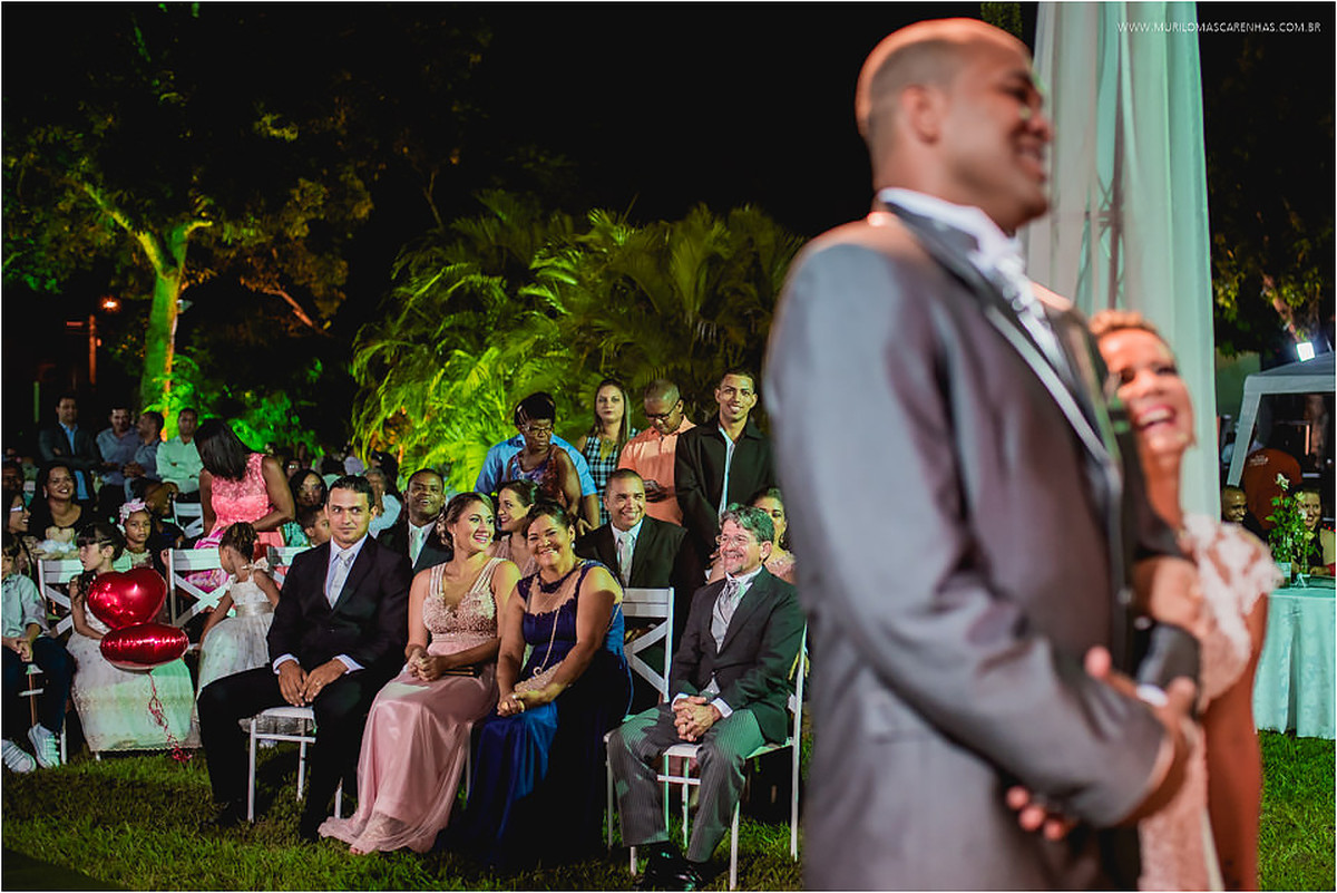 Padrinhos, madrinhas e pais sorriem durante a cerimônia