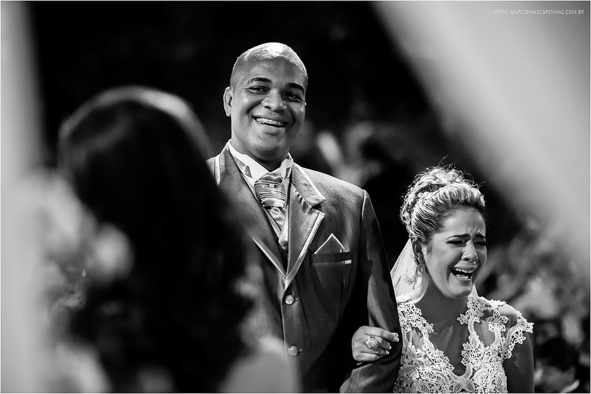 Noivo e noiva sorriem juntos