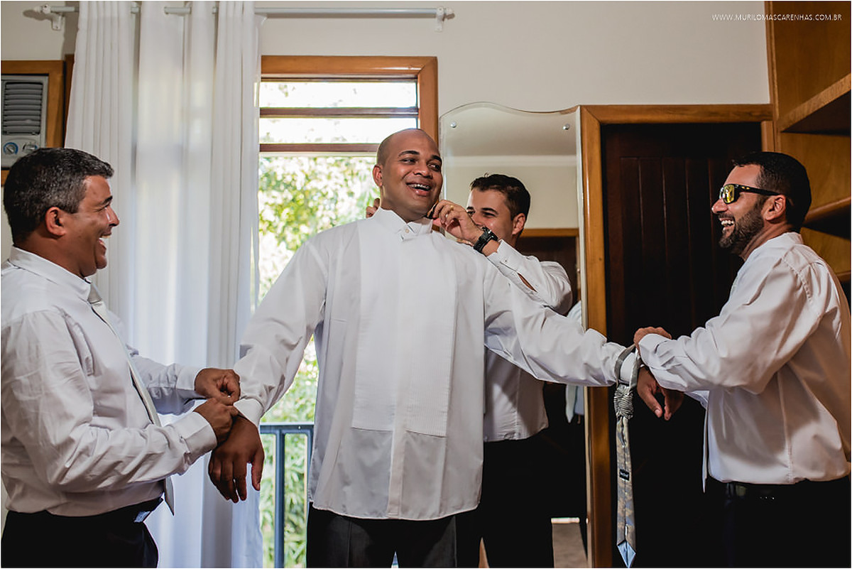 Noivo sendo arrumado pelos padrinhos durante o making of