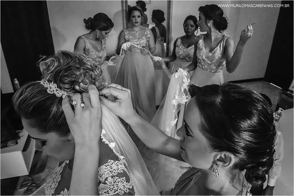 Irmã da noiva e madrinhas ajudando a colocar o véu