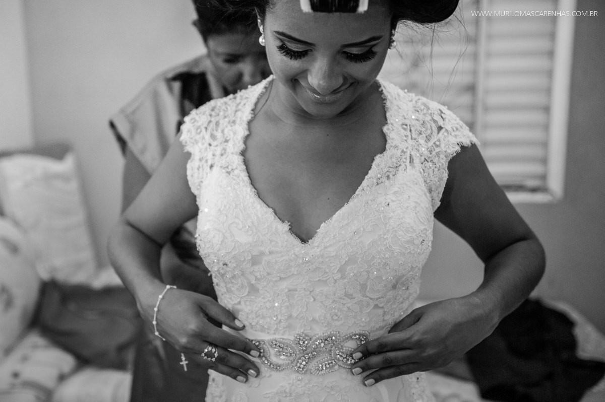 Mãe da noiva colocando o vestido na filha