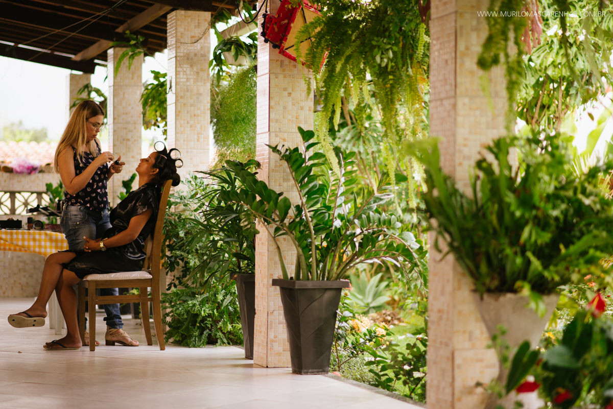 Noiva sendo maquiada no jardim da casa de seus pais