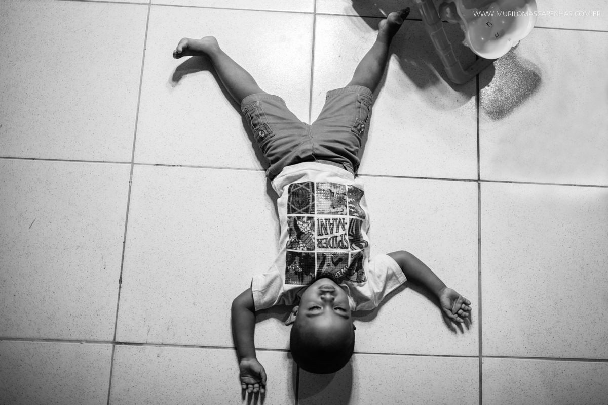 menino deitado no chão de pernas e braços abertos