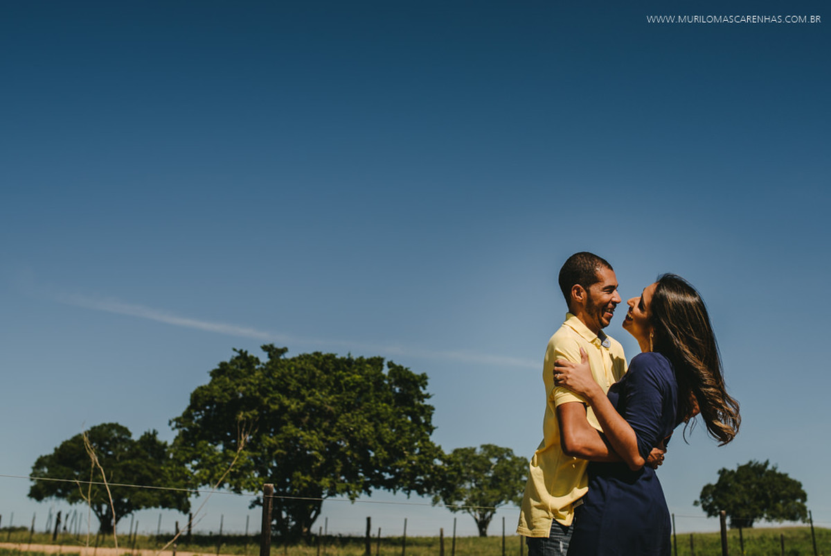 Noivos sorriem abraçados
