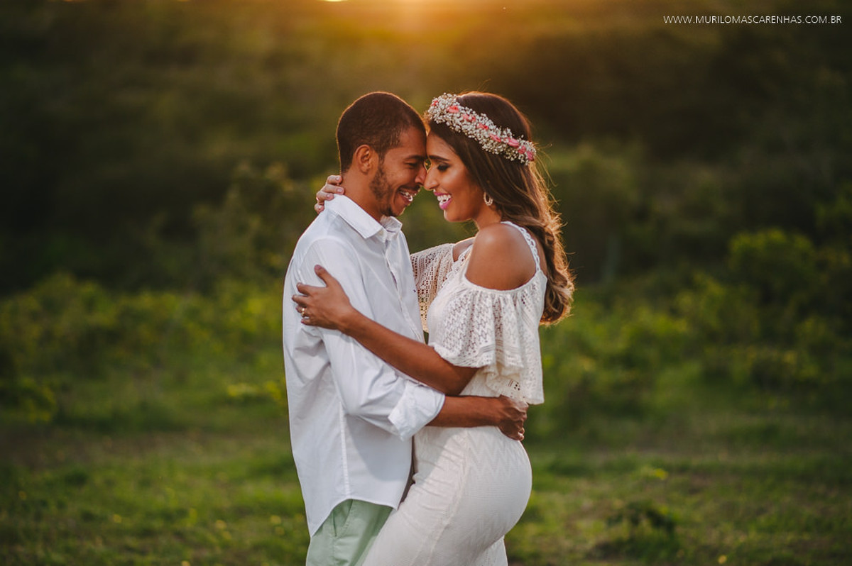 Noivos sorriem abraçados