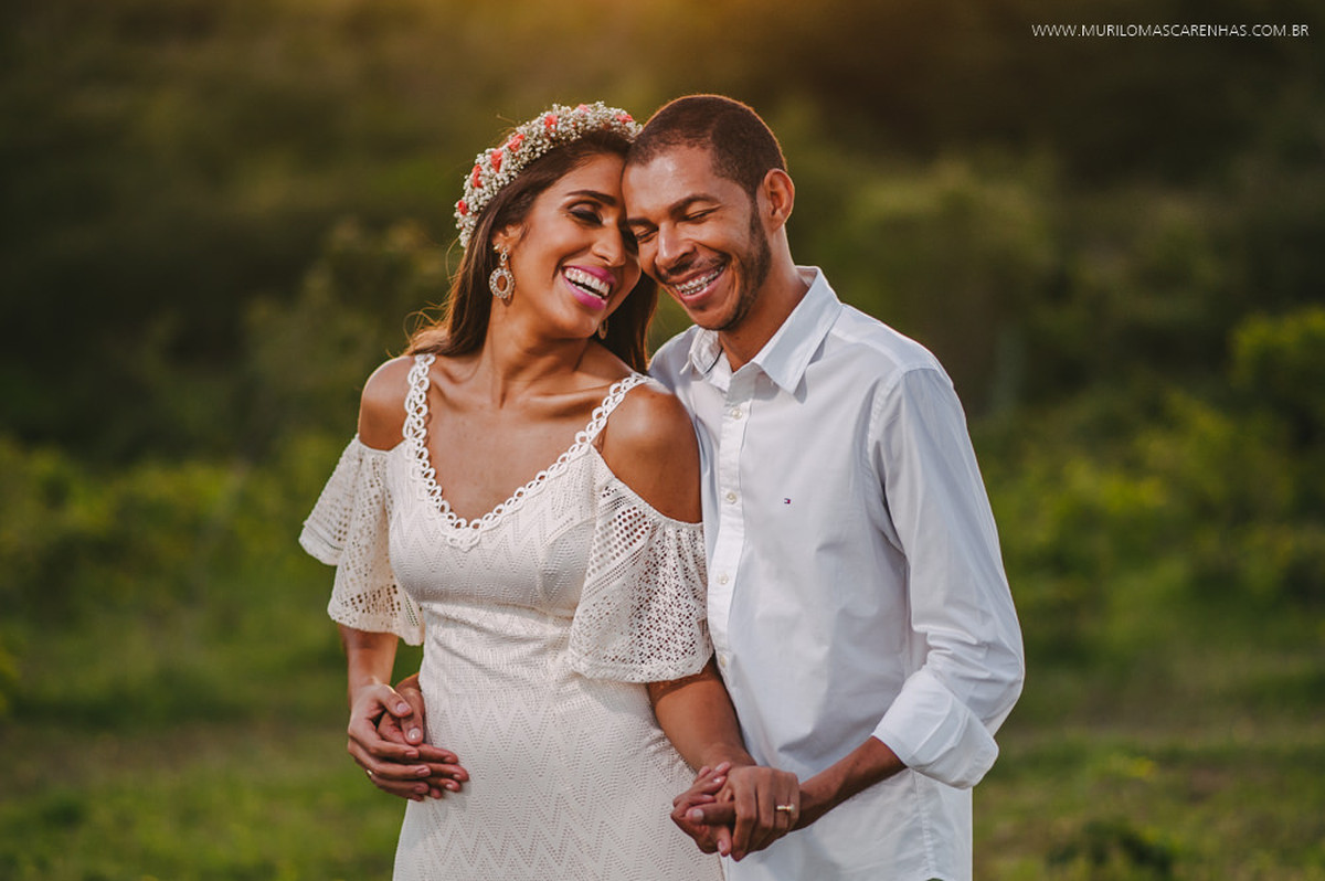 Noivos sorriem abraçados