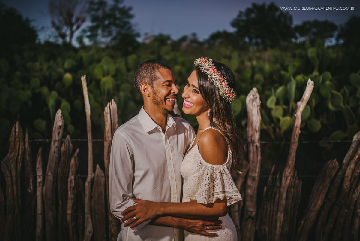Noivos sorriem abraçados
