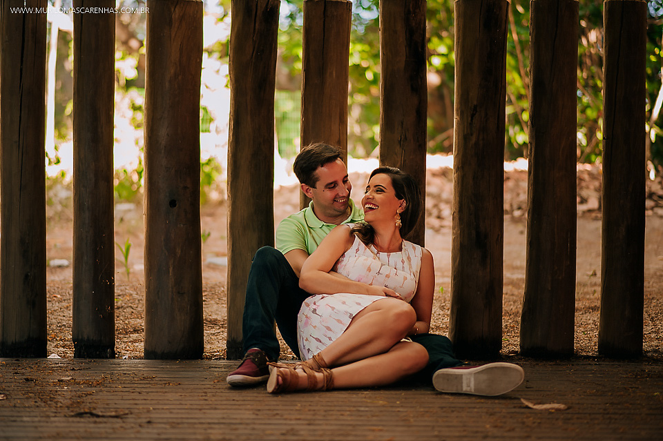 casal sentados sorrindo felizes amor ensaio pré casamento guarajuba praia do forte bahia feira de santana