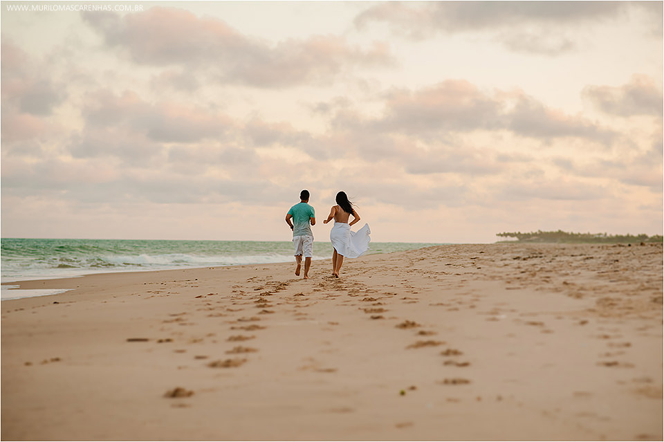 Ensaio de casal apaixonado, flamenguista, pre wedding, nas praias da linha verde, guarajuba, Bahia, fotografado por Murilo Mascarenhas de Feira de Santana. Pegadas na areia