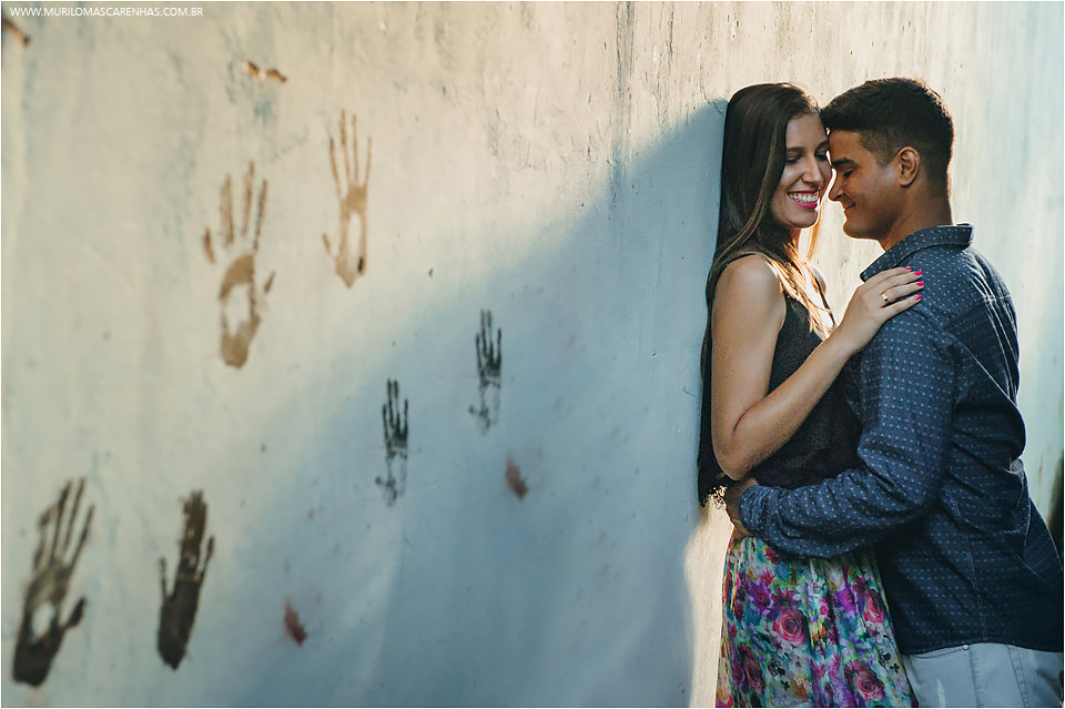 casal de feira de santana fazendo ensaio para casamento book na praia do forte salvador bahia feito por murilo mascarenhas fotografo abraçados na parede