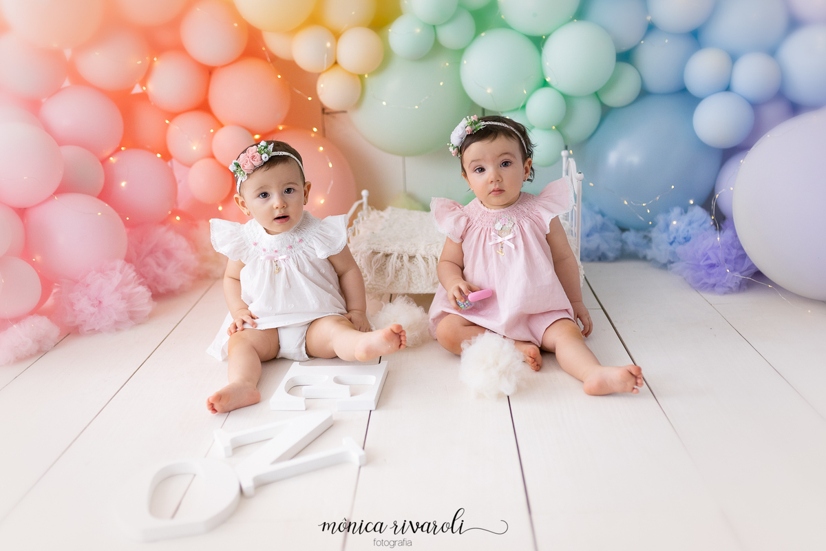 No cenário de Smash, as duas bebês estão sentadas uma ao lado da outra. No fundo tem uma mini cama e na frente das meninas está as letras da palavra 