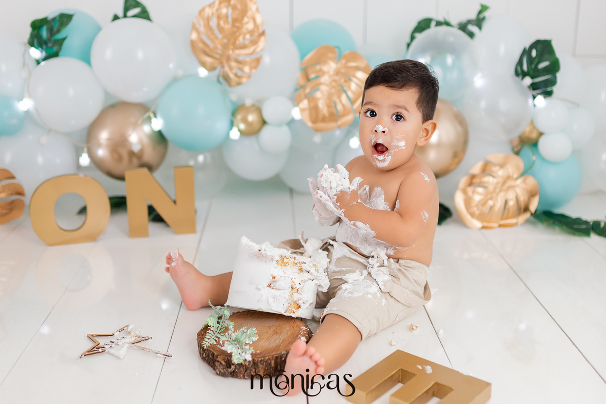 No cenário de Smash, o bebê está com o bolo na frente e as mãos próximas ao corpo, elas estão com bolo. A criança está com a boca aberta e o rosto lambuzado de chantilly.
Fotografado por Mônicas Fotografia em Maringá-PR