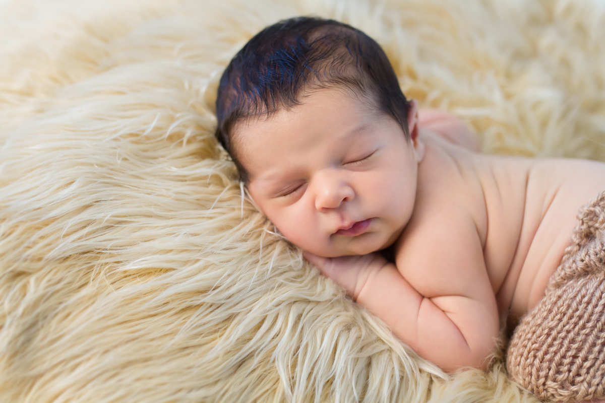Ele está deitadinho de costas com a mão nas bochechinhas