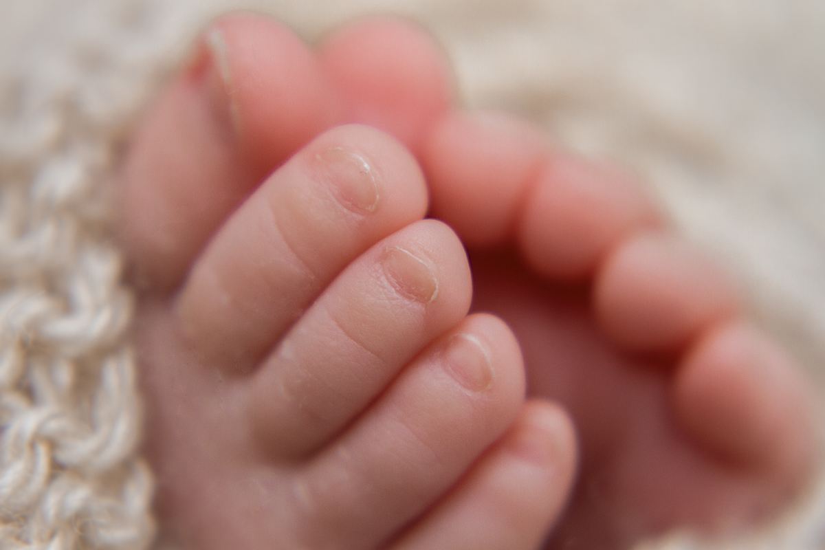 Os pézinhos juntinhos mostrando as unhas pequeninas