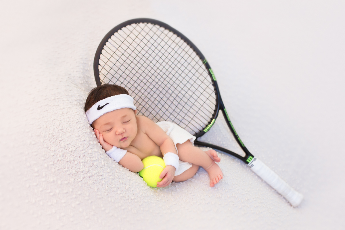 O papai da Gabi é tenista, aqui, ela está com uma roupinha de tenista, munhequeira e segurando a bolinha com uma raquete atrás dela