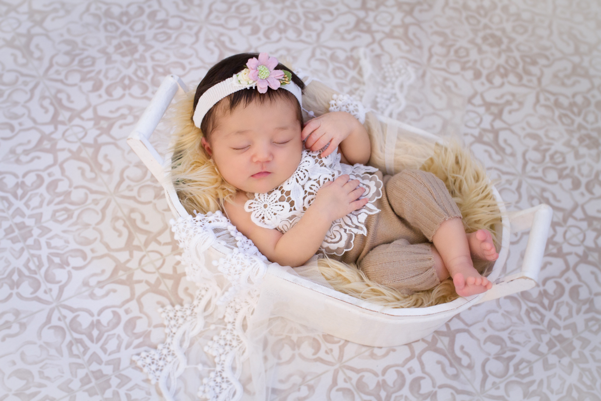 Dormindo em uma cestinha branca e um body todo rendando