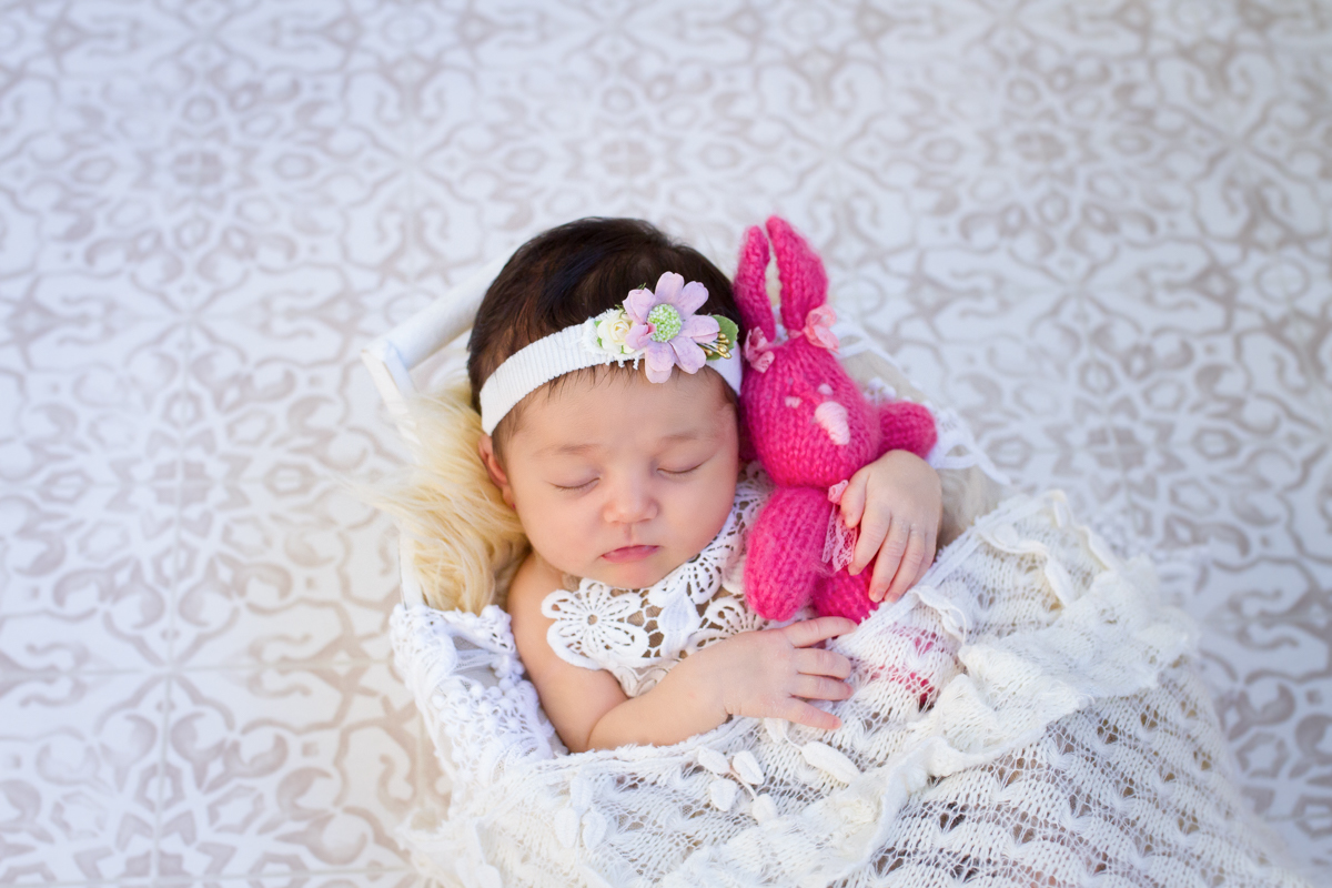 No mesmo cestinho, agora a Gabriela segura um ursinho de tricô