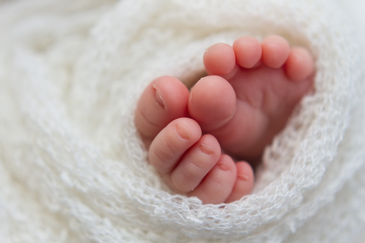 Os pezinhos enrolados em um tecido fofinho