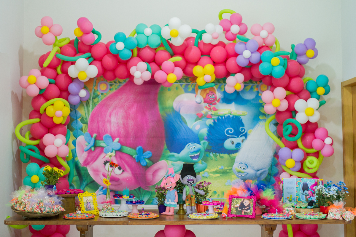 A mesa de doces, toda colorida. Com arcos de flores de bexigas coloridas na festa de aniversário da Rafa em Maringá